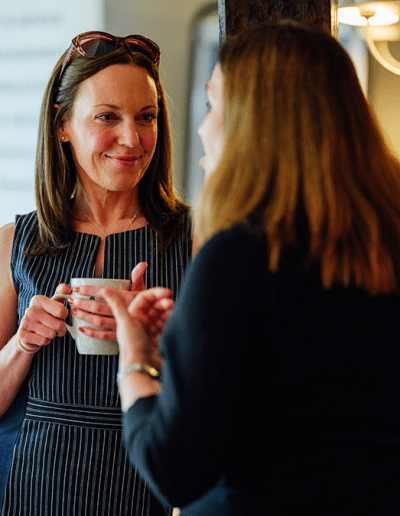 two women having a discussion over coffee