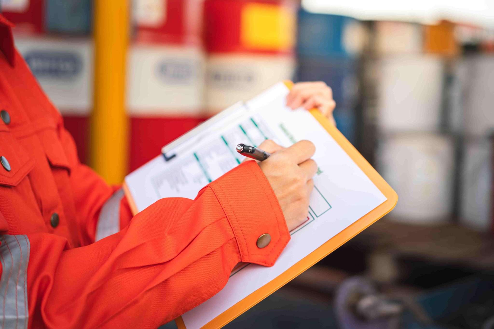 Person filling out health and safety documentation on a clipboard