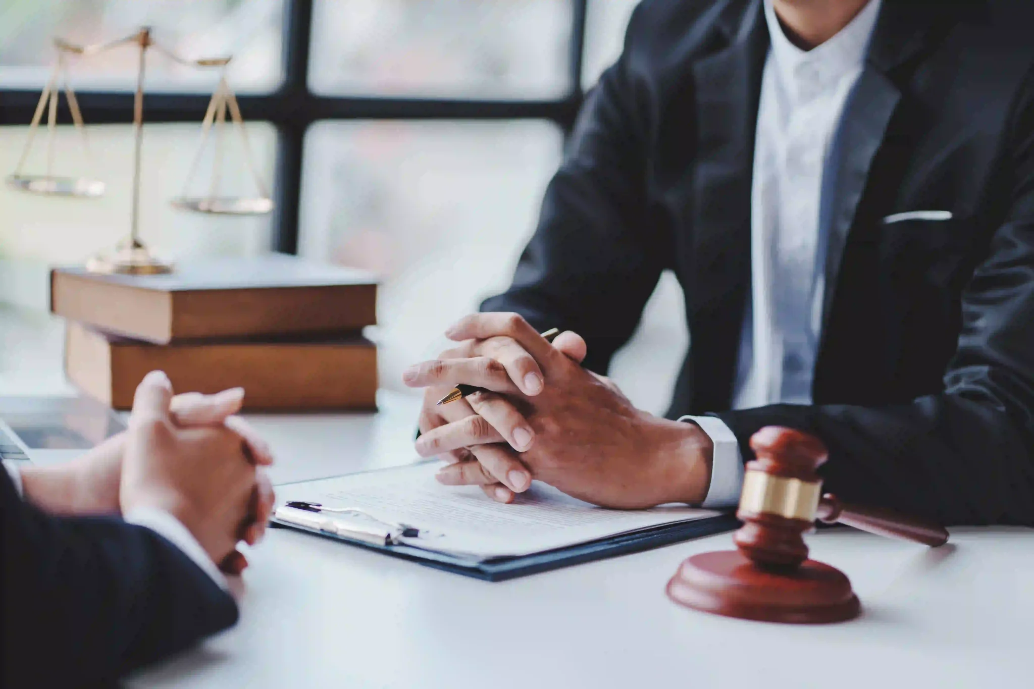 Employment law concept, with two men sitting across a desk, with a close up of hands and documentation